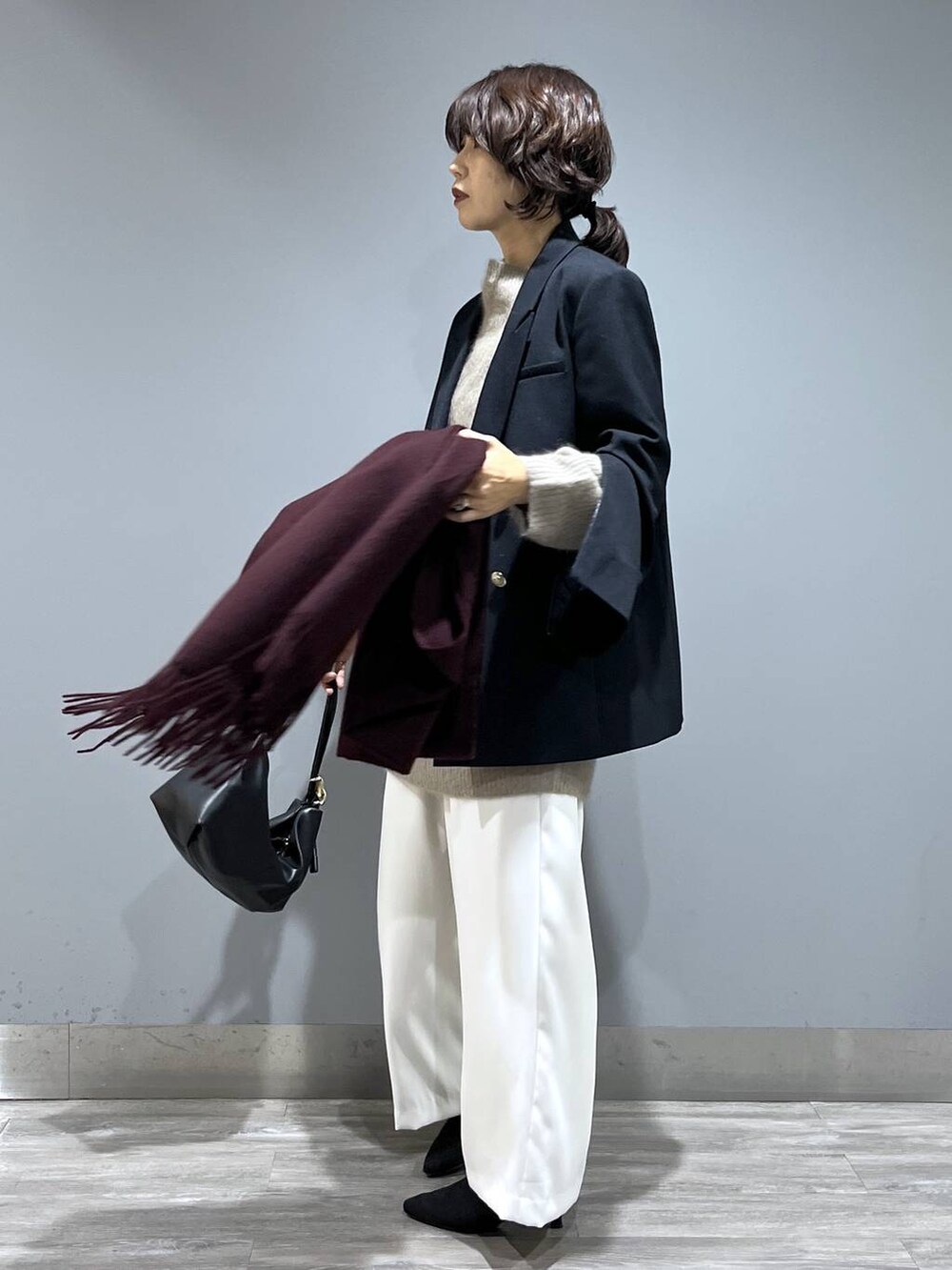 イエロー系のワンピース、ホワイト系のスラックス、ブルー系のテーラードジャケットを着用したレディースの秋コーディネートの4枚目の写真