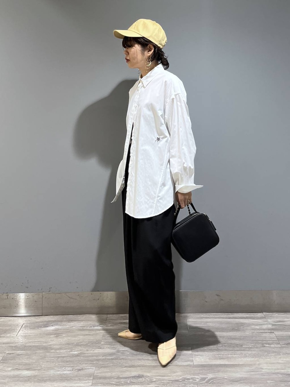 ブラック系のスラックス、ホワイト系のシャツ/ブラウス、ブラック系のショルダーバッグを着用したレディースの冬コーディネートの5枚目の写真