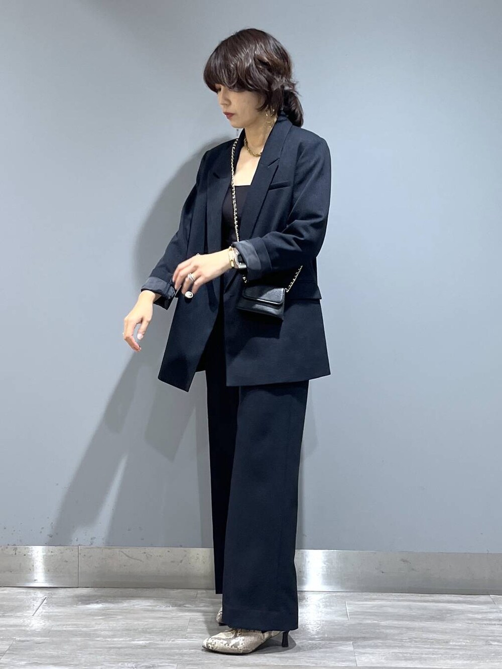 ブルー系のテーラードジャケット、ブルー系のスラックス、ベージュ系のブーツを着用したレディースの秋コーディネートの4枚目の写真