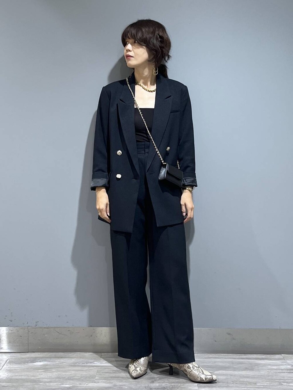 ブルー系のテーラードジャケット、ブルー系のスラックス、ベージュ系のブーツを着用したレディースの秋コーディネートの7枚目の写真