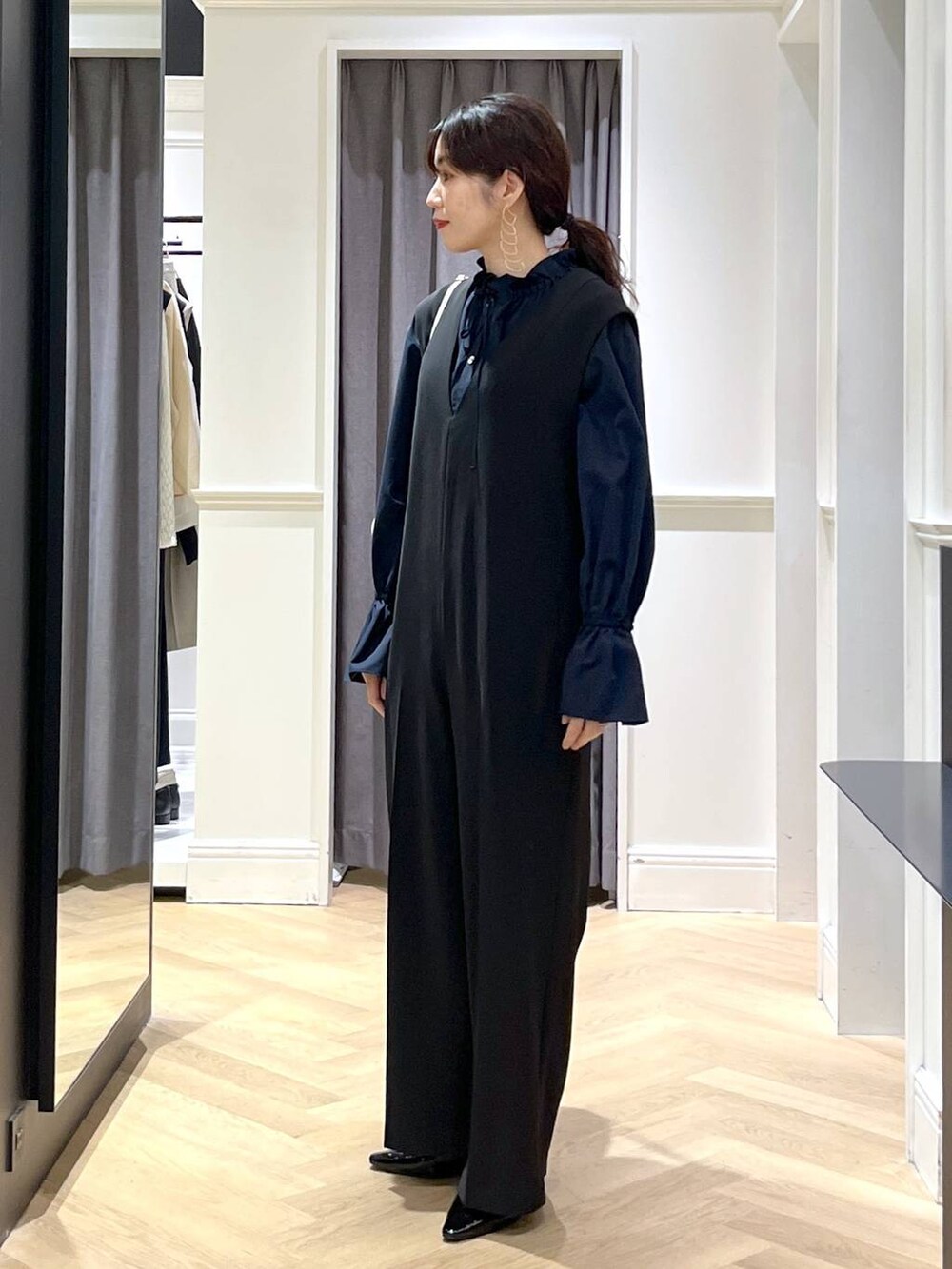 ホワイト系のショルダーバッグ、ブラック系のパンプス、ブラック系のサロペット/オーバーオールを着用したレディースの冬コーディネートの5枚目の写真