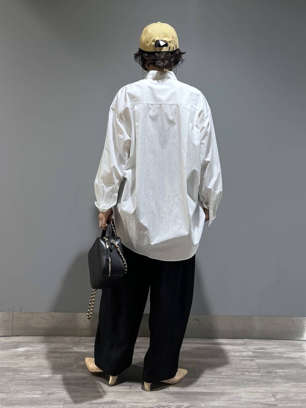 ブラック系のスラックス、ホワイト系のシャツ/ブラウス、ブラック系のショルダーバッグを着用したレディースの冬コーディネートの3枚目の写真