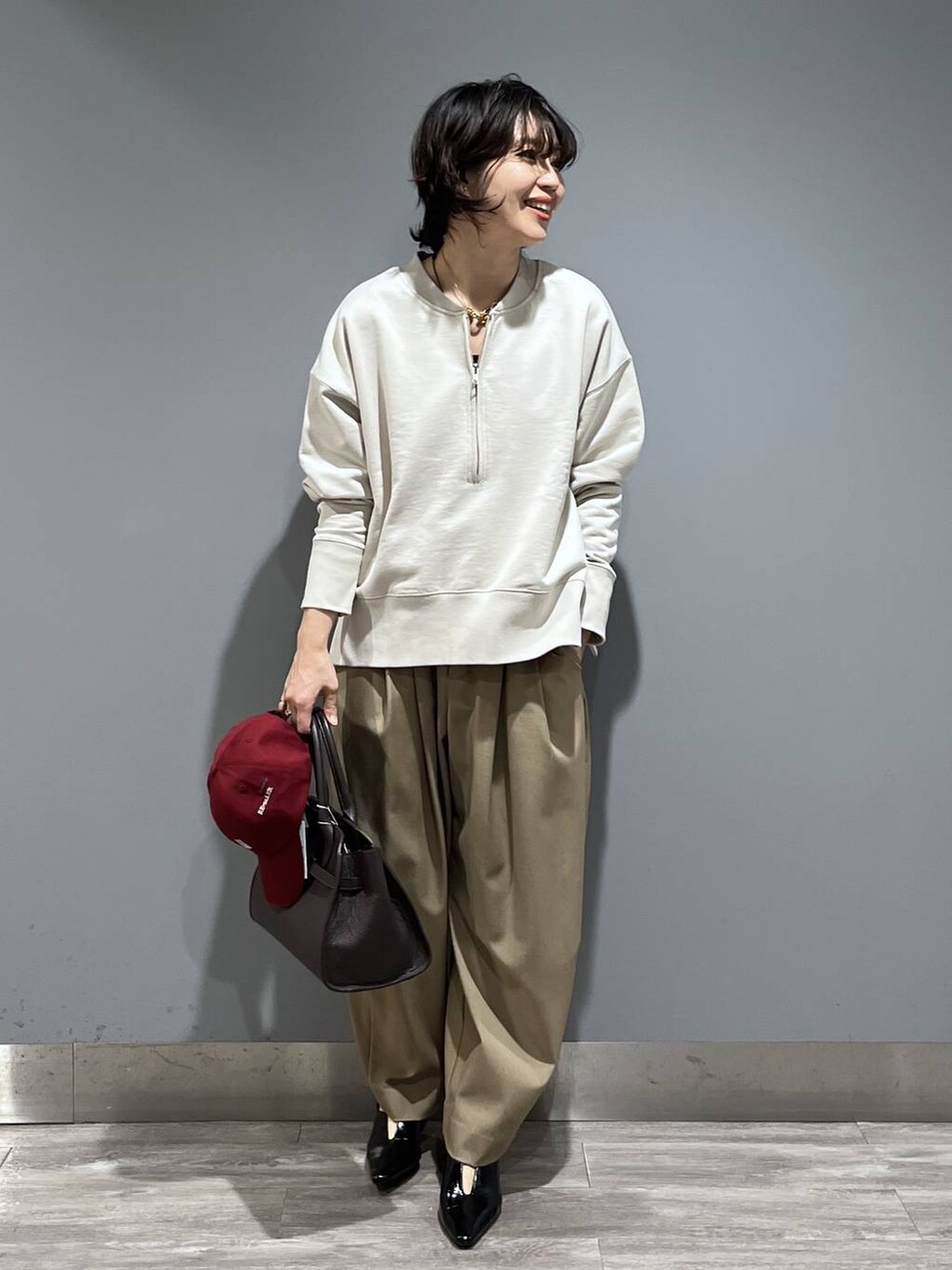 ベージュ系のスラックス、ブラック系のパンプス、ブラウン系のショルダーバッグを着用したレディースの冬コーディネートの7枚目の写真