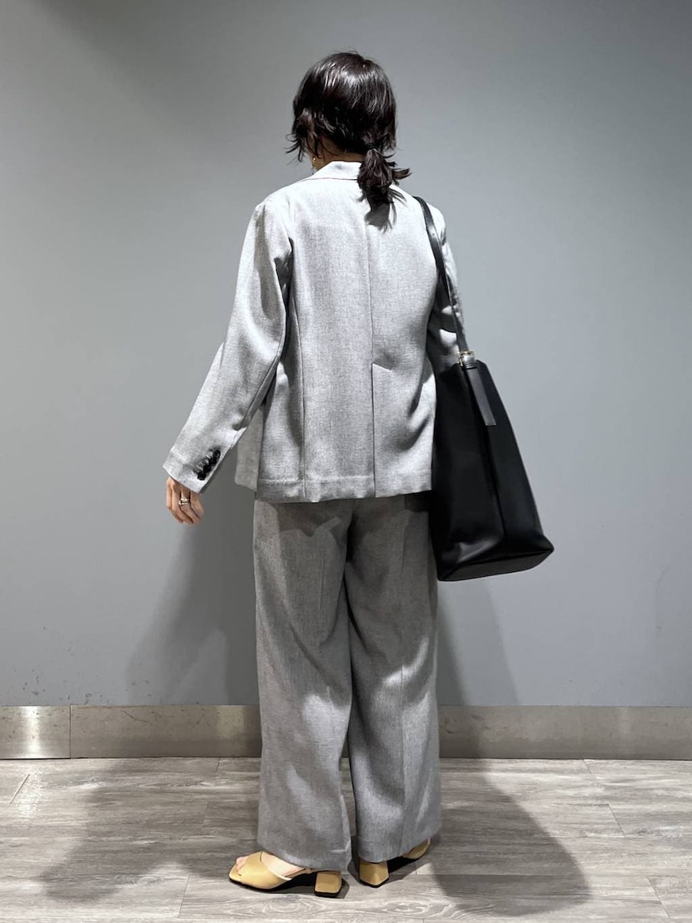 ブラック系のトートバッグ、ブラック系のノーカラージャケット、ブラック系のベストを着用したレディースの春コーディネートの3枚目の写真