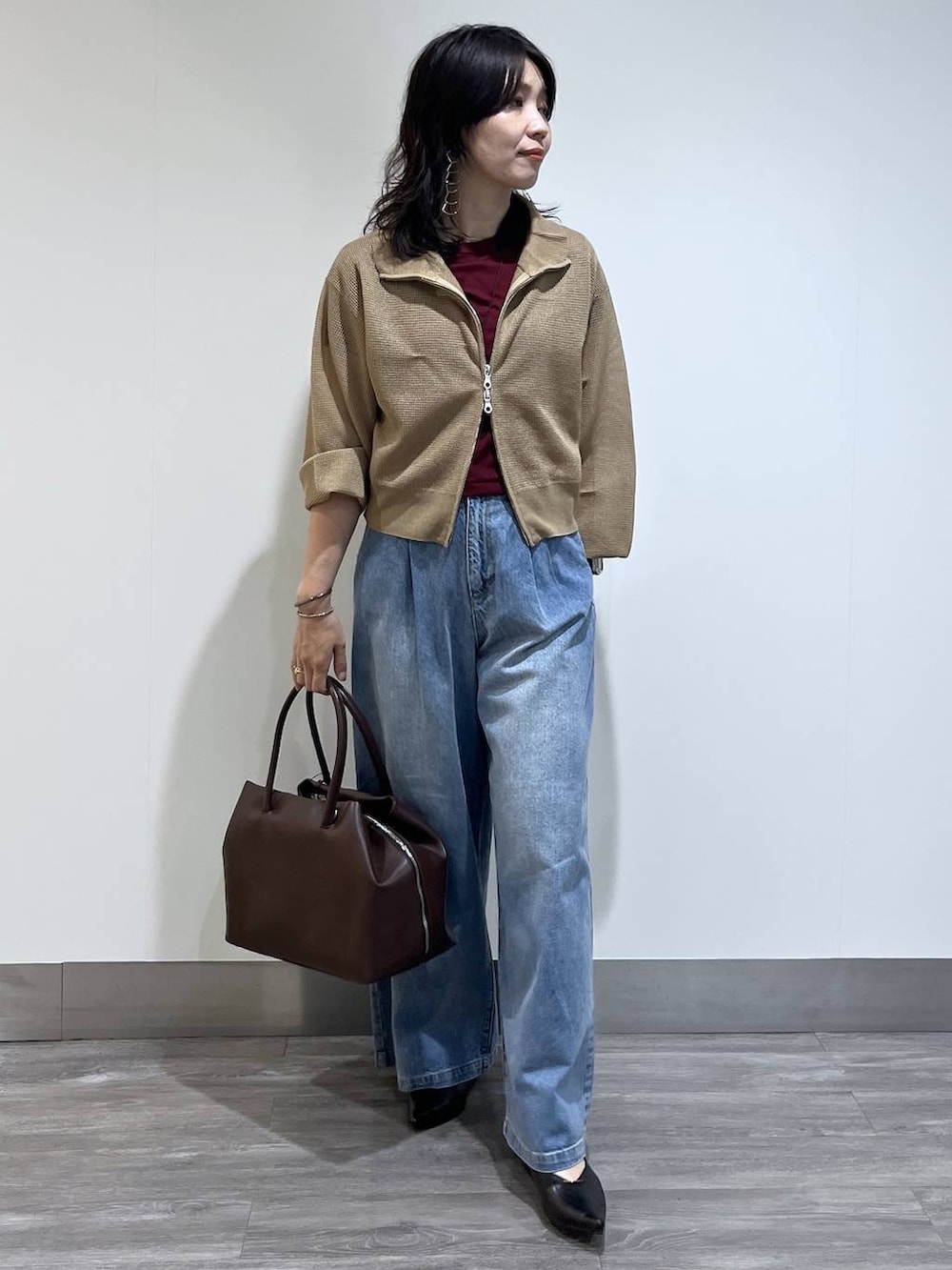 ベージュ系のブルゾン、ブラック系のパンプス、レッド系のTシャツ/カットソーを着用したレディースの夏コーディネートの6枚目の写真