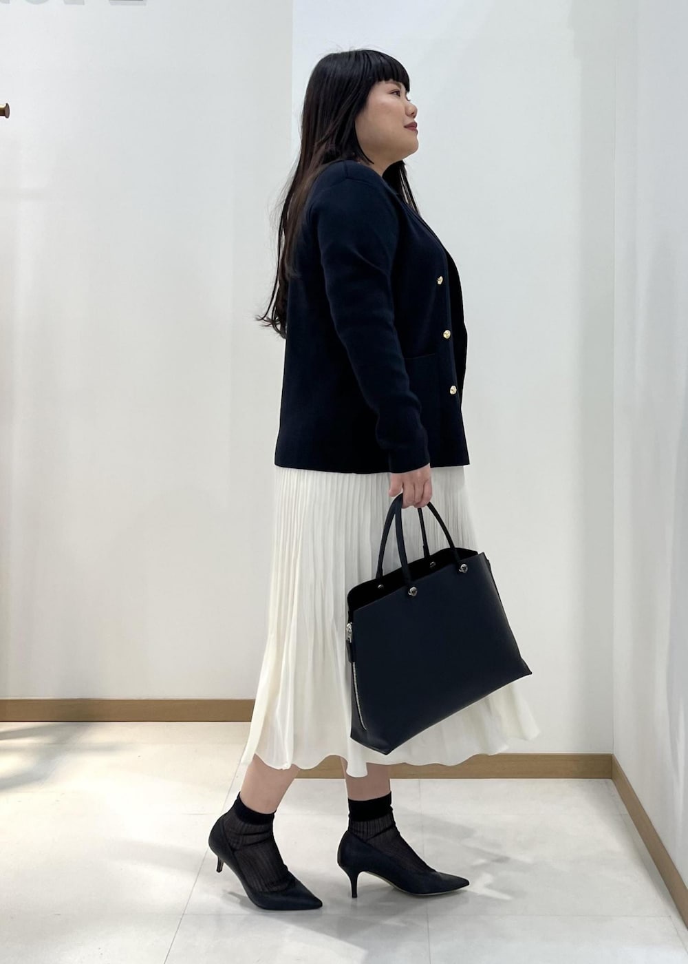 ホワイト系のスカート、ブルー系のテーラードジャケット、オレンジ系のTシャツ/カットソーを着用したレディースの春コーディネートの2枚目の写真