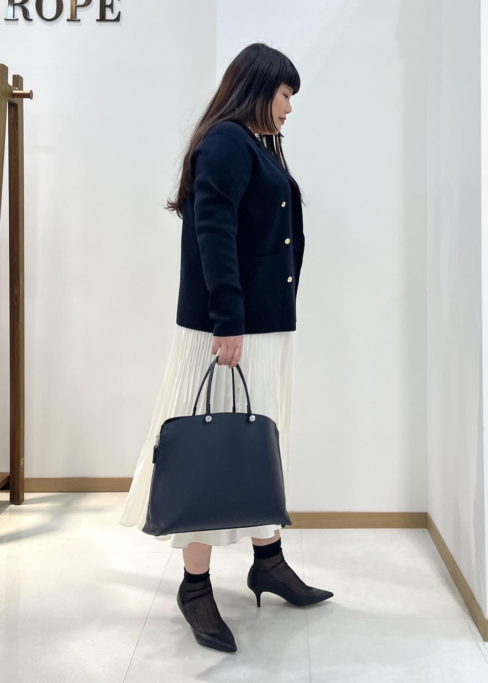 ホワイト系のスカート、ブルー系のテーラードジャケット、オレンジ系のTシャツ/カットソーを着用したレディースの春コーディネートの3枚目の写真