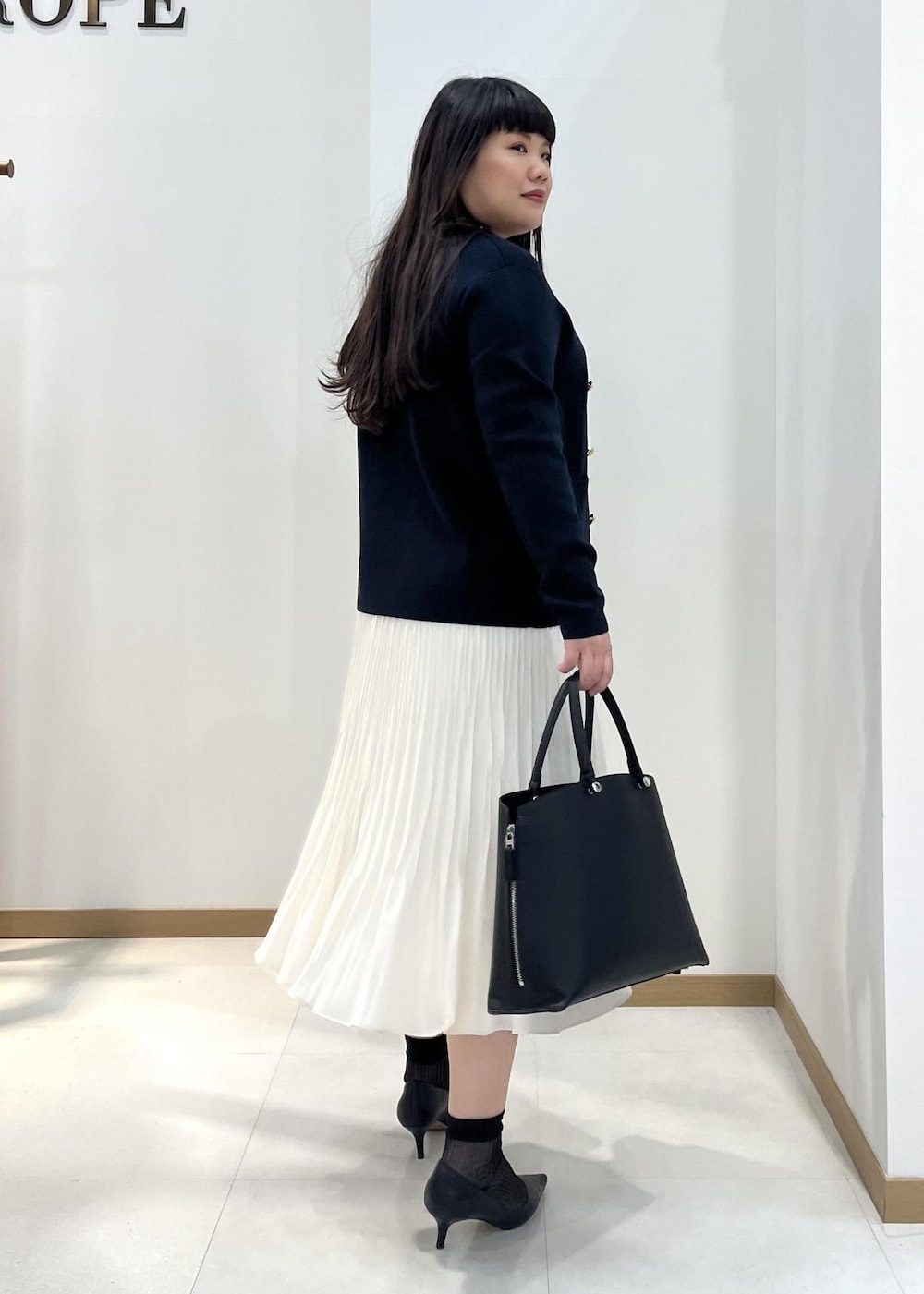 ホワイト系のスカート、ブルー系のテーラードジャケット、オレンジ系のTシャツ/カットソーを着用したレディースの春コーディネートの4枚目の写真