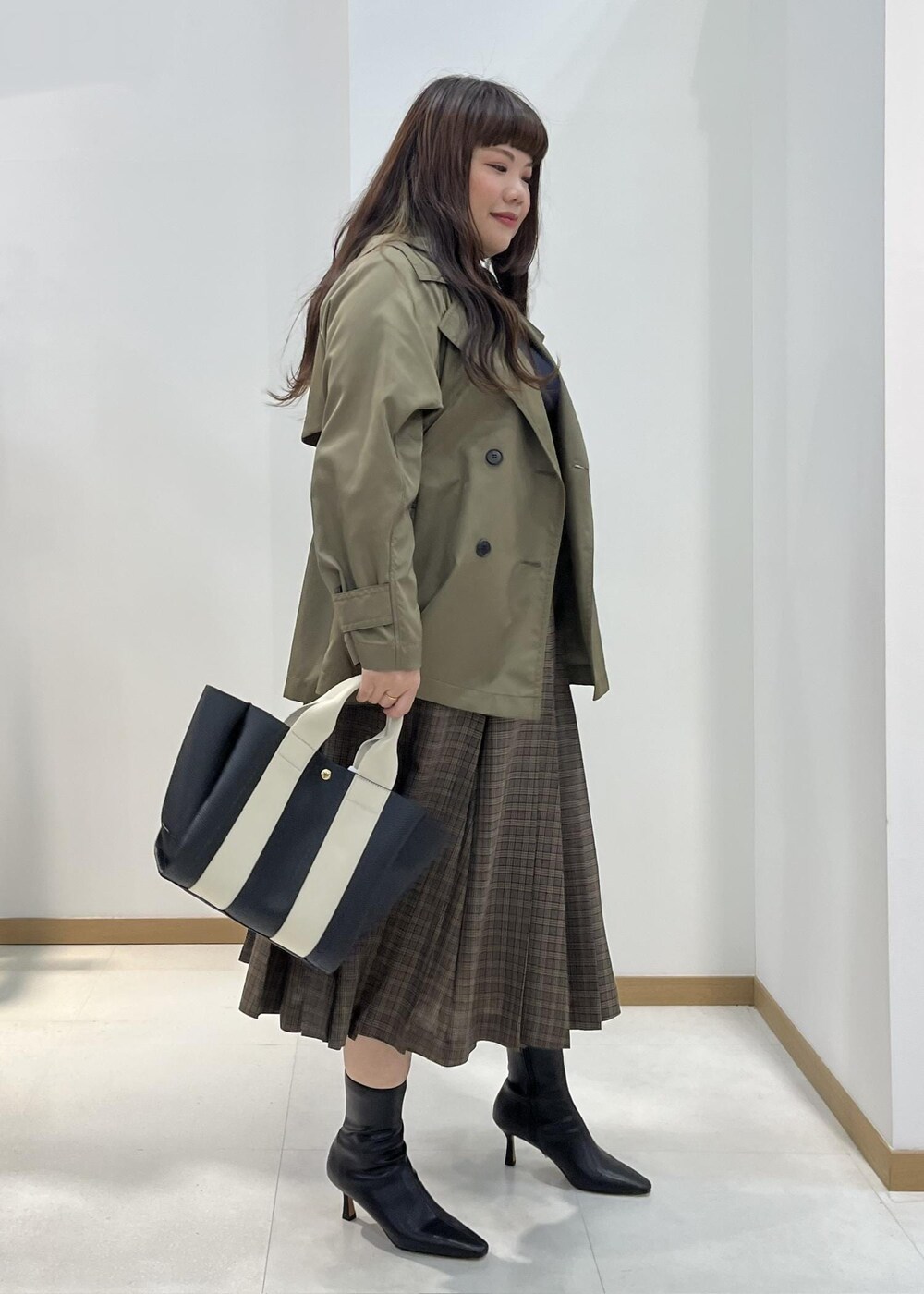 ブラック系のブーツ、ブラック系のトートバッグ、ブルー系のニット/セーターを着用したレディースの秋コーディネートの2枚目の写真