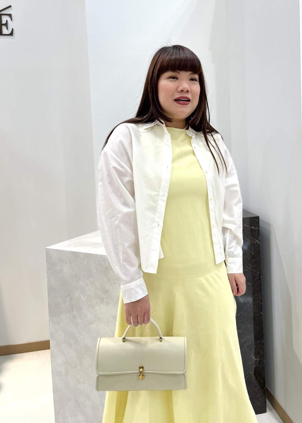 ベージュ系のショルダーバッグ、ホワイト系のシャツ/ブラウス、ベージュ系のサンダルを着用したレディースの春コーディネートの4枚目の写真