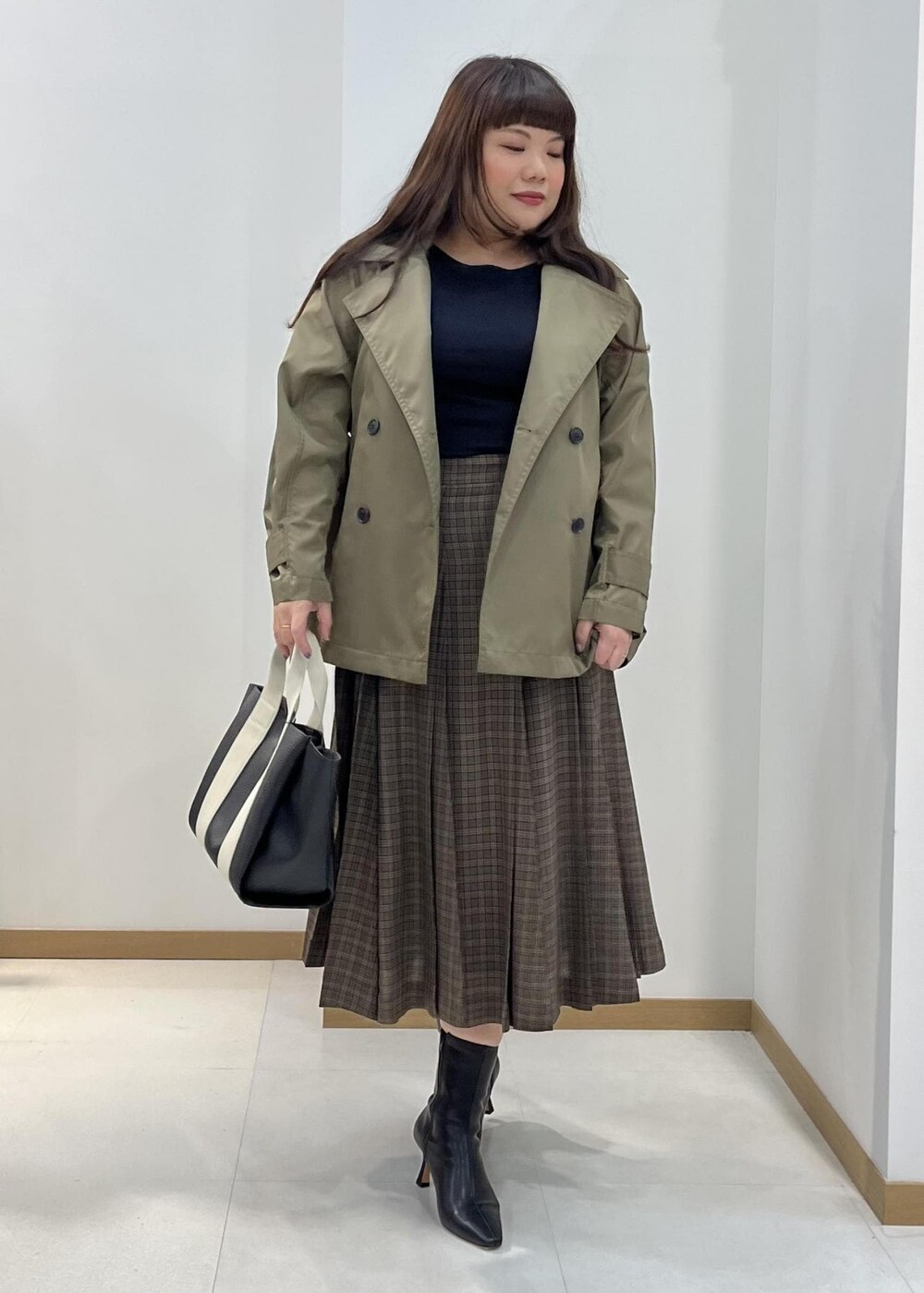 ブラック系のブーツ、ブラック系のトートバッグ、ブルー系のニット/セーターを着用したレディースの秋コーディネートの4枚目の写真