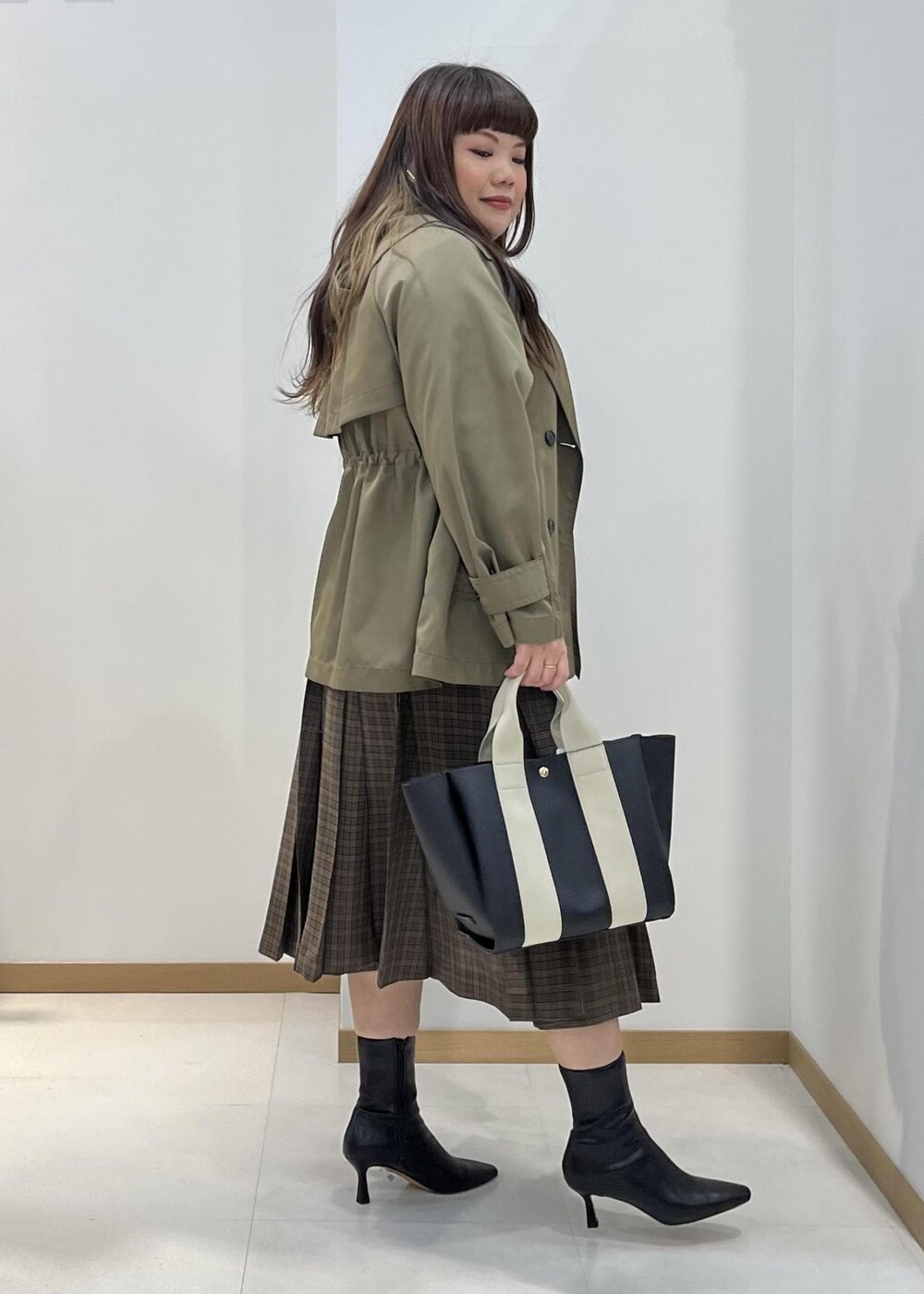 ブラック系のブーツ、ブラック系のトートバッグ、ブルー系のニット/セーターを着用したレディースの秋コーディネートの3枚目の写真