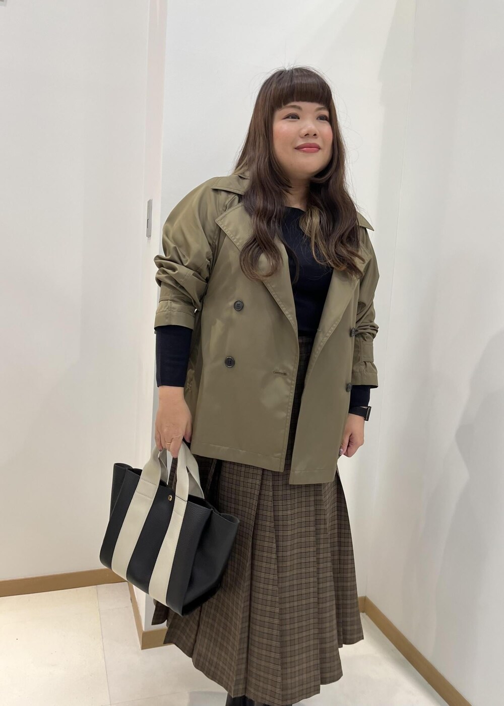 ブラック系のブーツ、ブラック系のトートバッグ、ブルー系のニット/セーターを着用したレディースの秋コーディネートの5枚目の写真