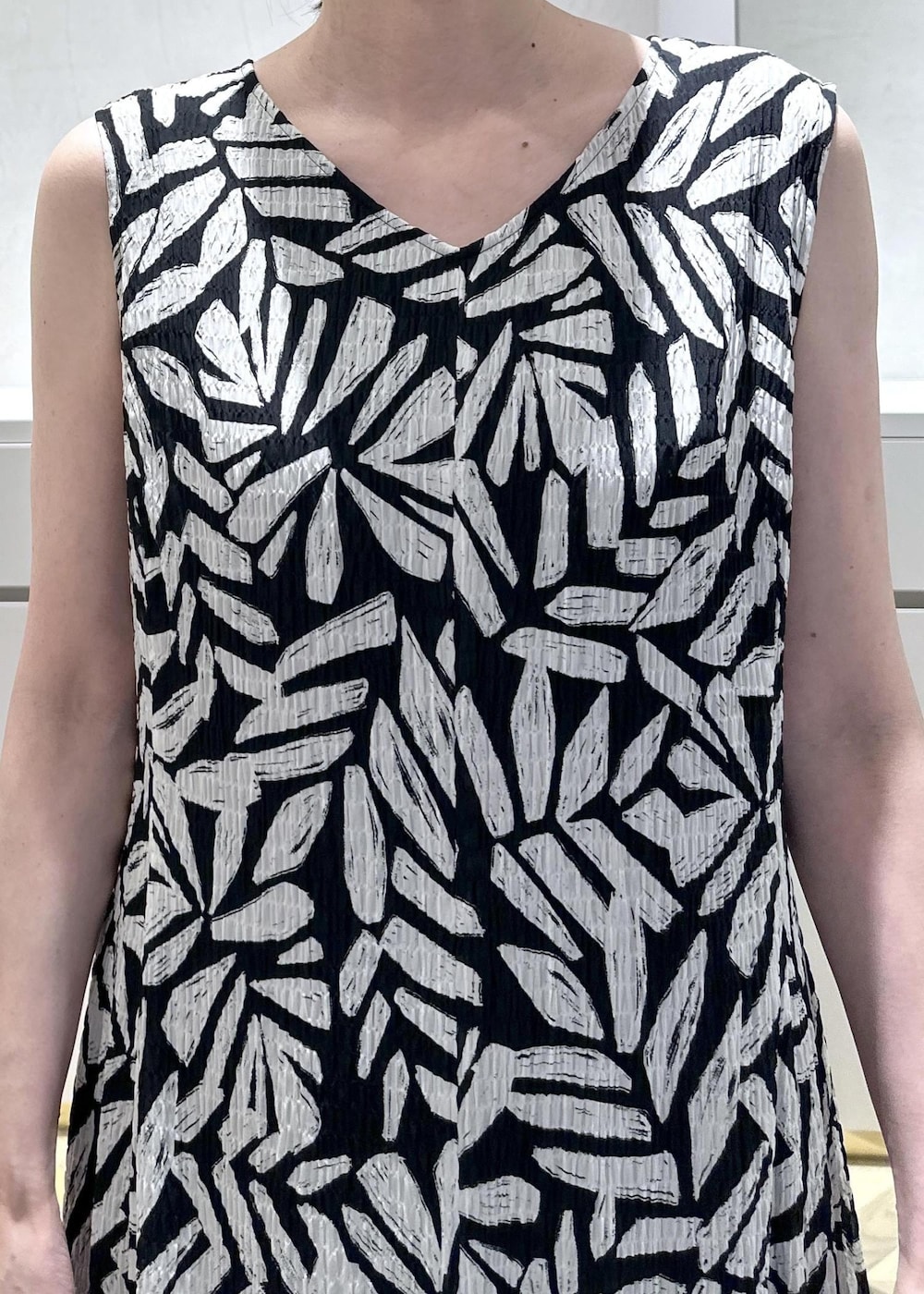 ホワイト系のショルダーバッグ、ブラック系のサンダル、ホワイト系のベストを着用したレディースの夏コーディネートの8枚目の写真