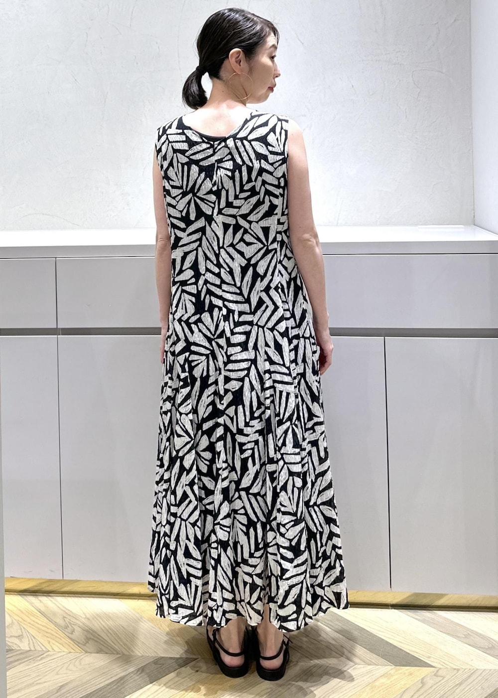 ホワイト系のショルダーバッグ、ブラック系のサンダル、ホワイト系のベストを着用したレディースの夏コーディネートの10枚目の写真