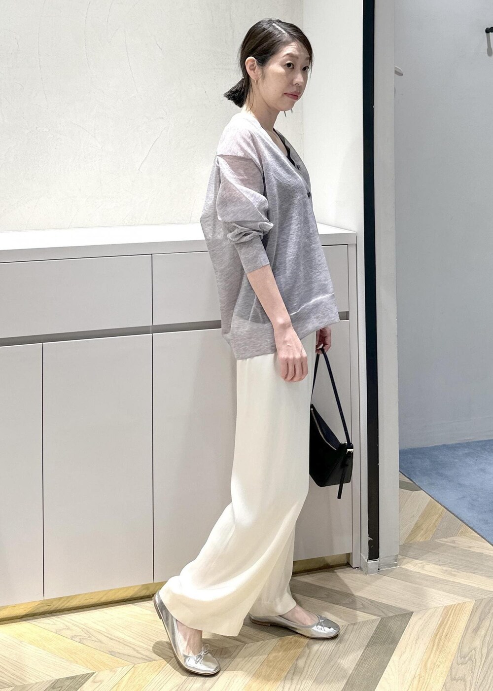 ブラック系のハンドバッグ、ホワイト系のその他パンツ、グレー系のカーディガン/ボレロを着用したレディースの春コーディネートの3枚目の写真