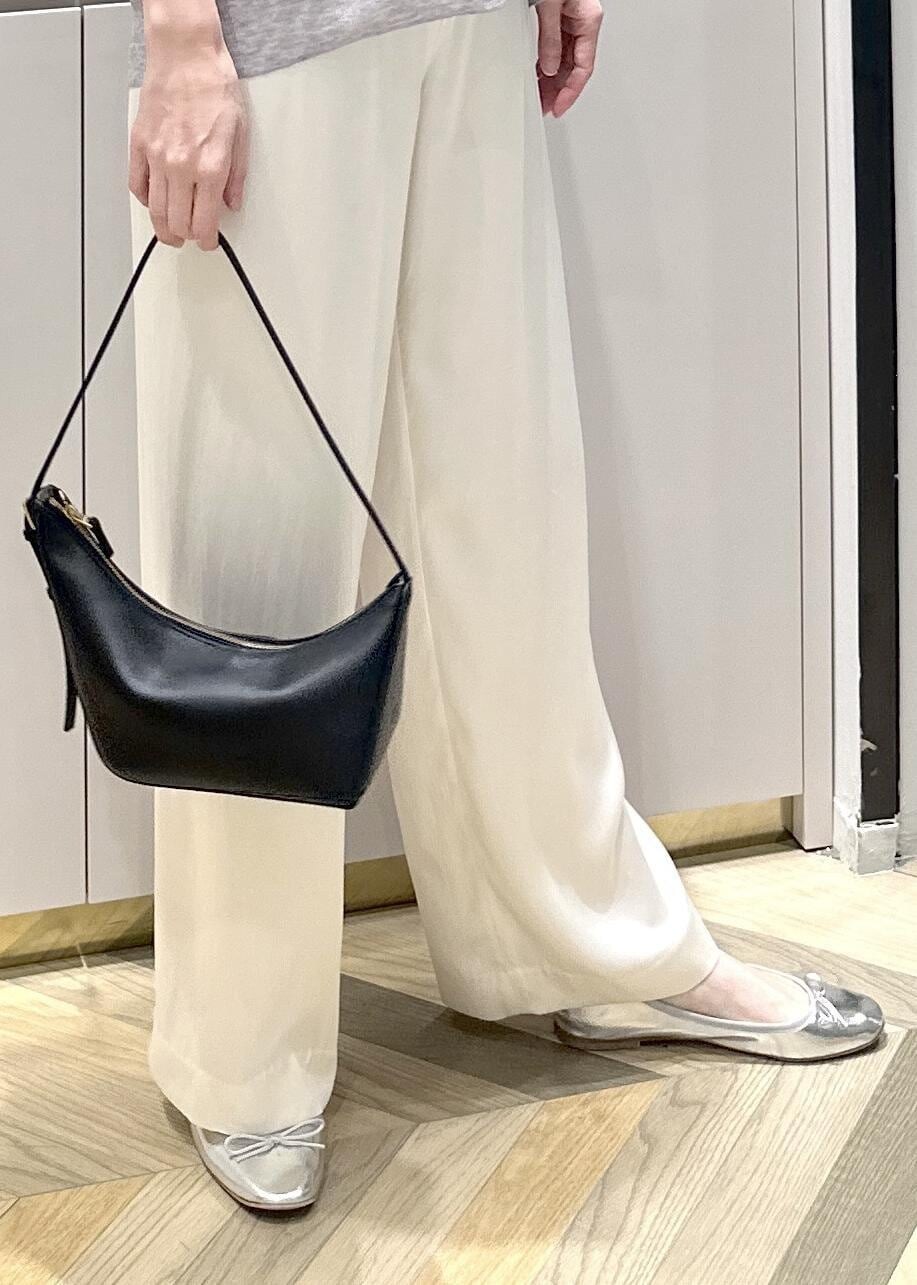 ブラック系のハンドバッグ、ホワイト系のその他パンツ、グレー系のカーディガン/ボレロを着用したレディースの春コーディネートの6枚目の写真