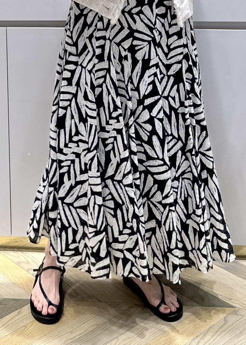 ホワイト系のショルダーバッグ、ブラック系のサンダル、ホワイト系のベストを着用したレディースの夏コーディネートの7枚目の写真