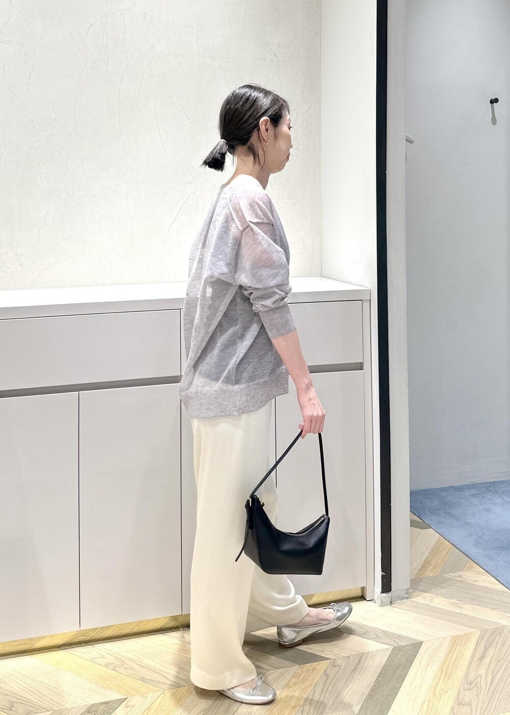 ブラック系のハンドバッグ、ホワイト系のその他パンツ、グレー系のカーディガン/ボレロを着用したレディースの春コーディネートの5枚目の写真