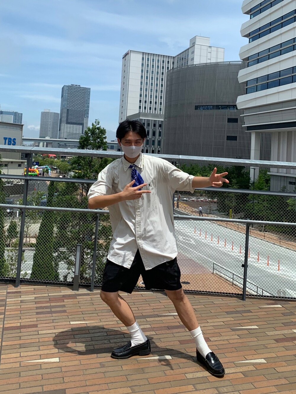 ブラック系のローファー、ブラック系のカーゴパンツ、ブラック系のショルダーバッグを着用したメンズの夏コーディネートの2枚目の写真