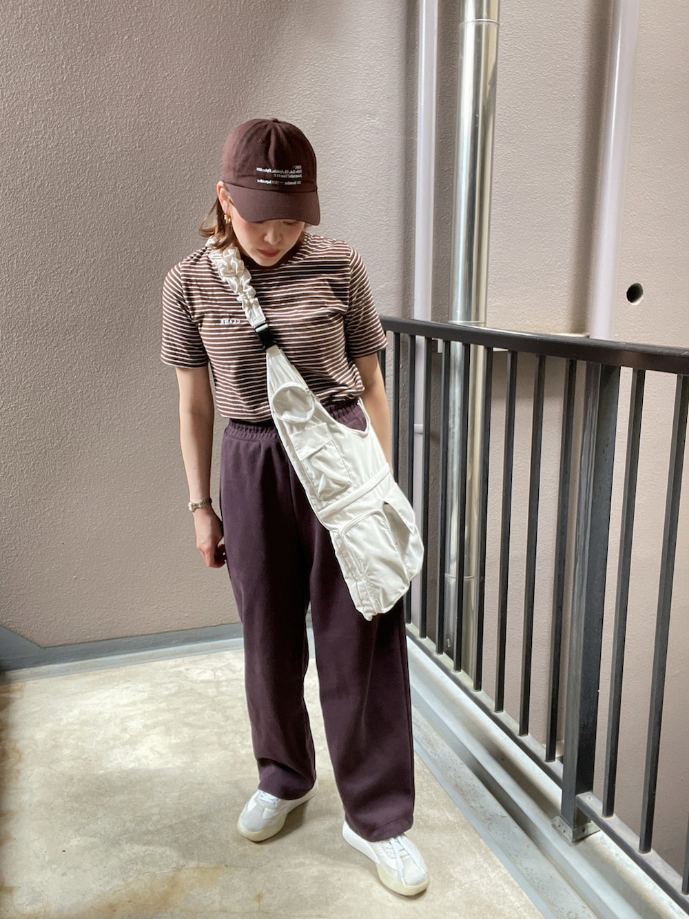 ホワイト系のトートバッグ、ブラウン系のTシャツ/カットソー、ブラウン系のスウェットパンツを着用したレディースの夏コーディネートの2枚目の写真