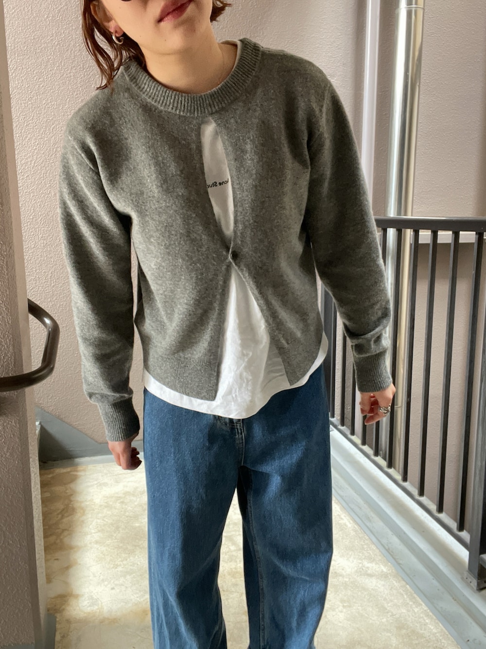 ブルー系のデニムパンツ、グレー系のスニーカー、グレー系のニット/セーターを着用したレディースの春コーディネートの2枚目の写真