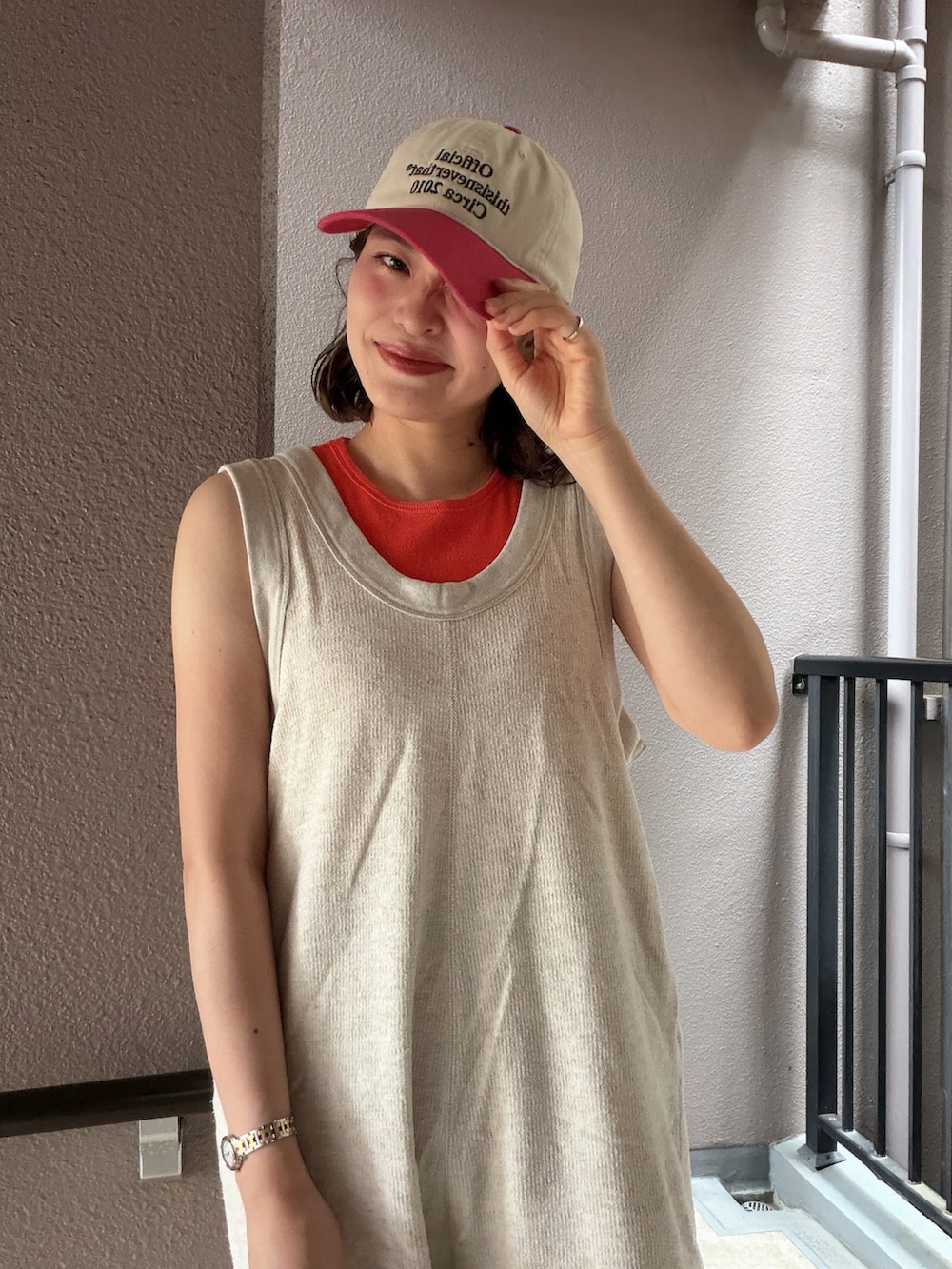 ベージュ系のつなぎ/オールインワン、レッド系のタンクトップ、ベージュ系のキャップを着用したレディースの夏コーディネートの3枚目の写真