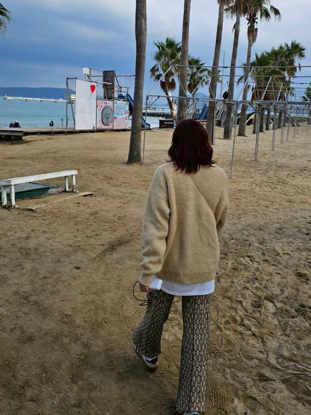 ベージュ系のニット/セーター、ベージュ系のその他パンツ、ベージュ系のスニーカーを着用したレディースの冬コーディネートの2枚目の写真