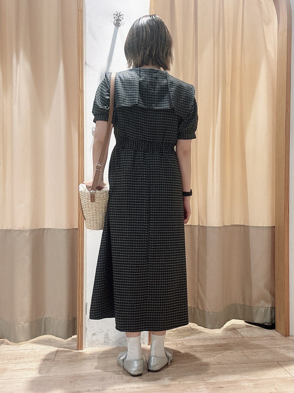 ブラック系のワンピース、ブラウン系のハンドバッグを着用したレディースの春コーディネートの4枚目の写真