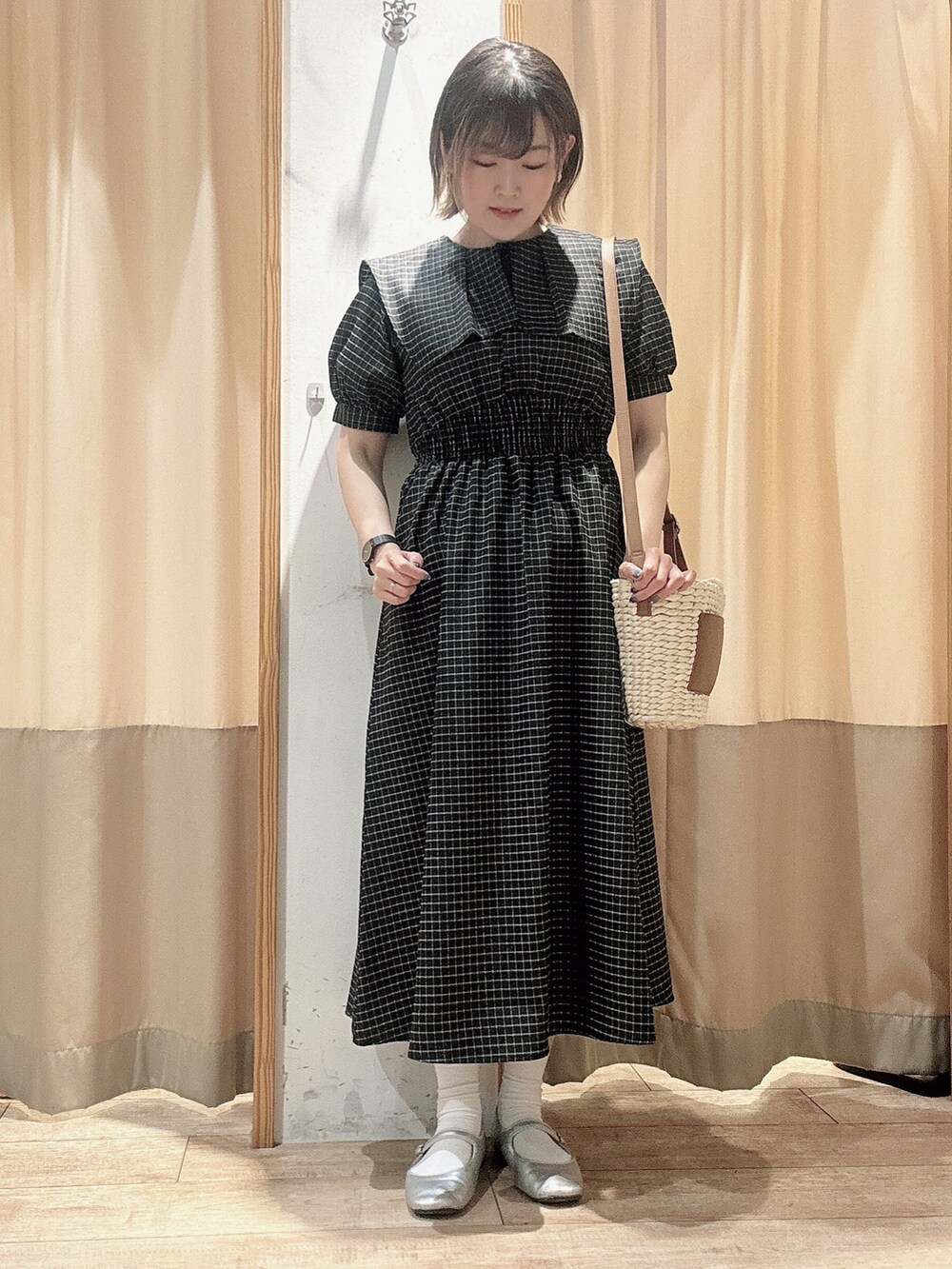 ブラック系のワンピース、ブラウン系のハンドバッグを着用したレディースの春コーディネートの3枚目の写真