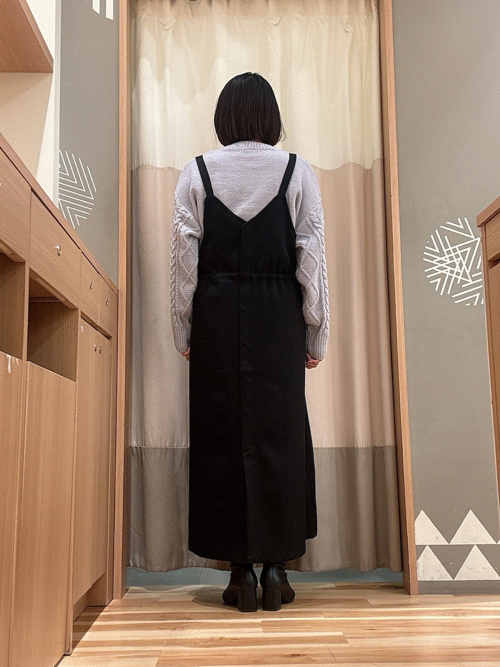 ブルー系のニット/セーター、ブラック系のワンピース、ブラック系のハンドバッグを着用したレディースの冬コーディネートの2枚目の写真