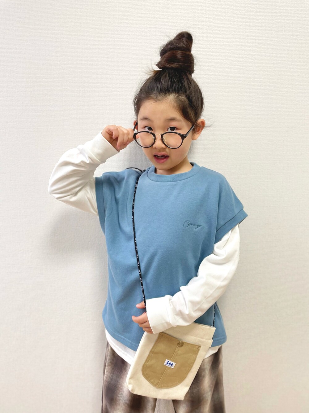 ブルー系のTシャツ/カットソー、ベージュ系のショルダーバッグ、ブラウン系のその他パンツを着用したキッズの冬コーディネートの2枚目の写真