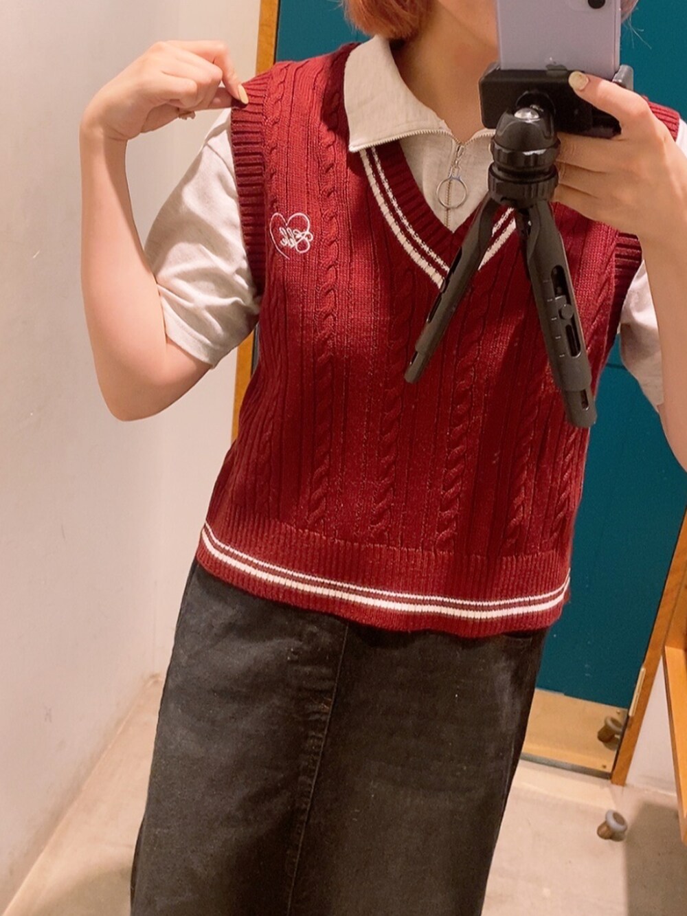 レッド系のベスト、グレー系のTシャツ/カットソー、ブラック系のスカートを着用したレディースの秋コーディネートの2枚目の写真