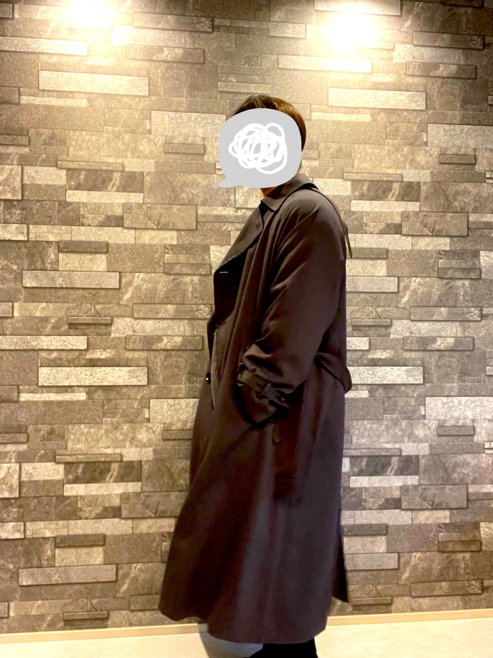 グレー系のトレンチコート、グレー系のニット/セーター、ブラック系のパンツを着用したメンズの冬コーディネートの3枚目の写真