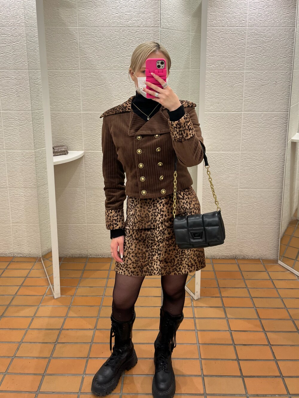 ブラウン系のフォーマルスーツ/小物、ブラック系のバッグを着用したレディースの冬コーディネートの2枚目の写真