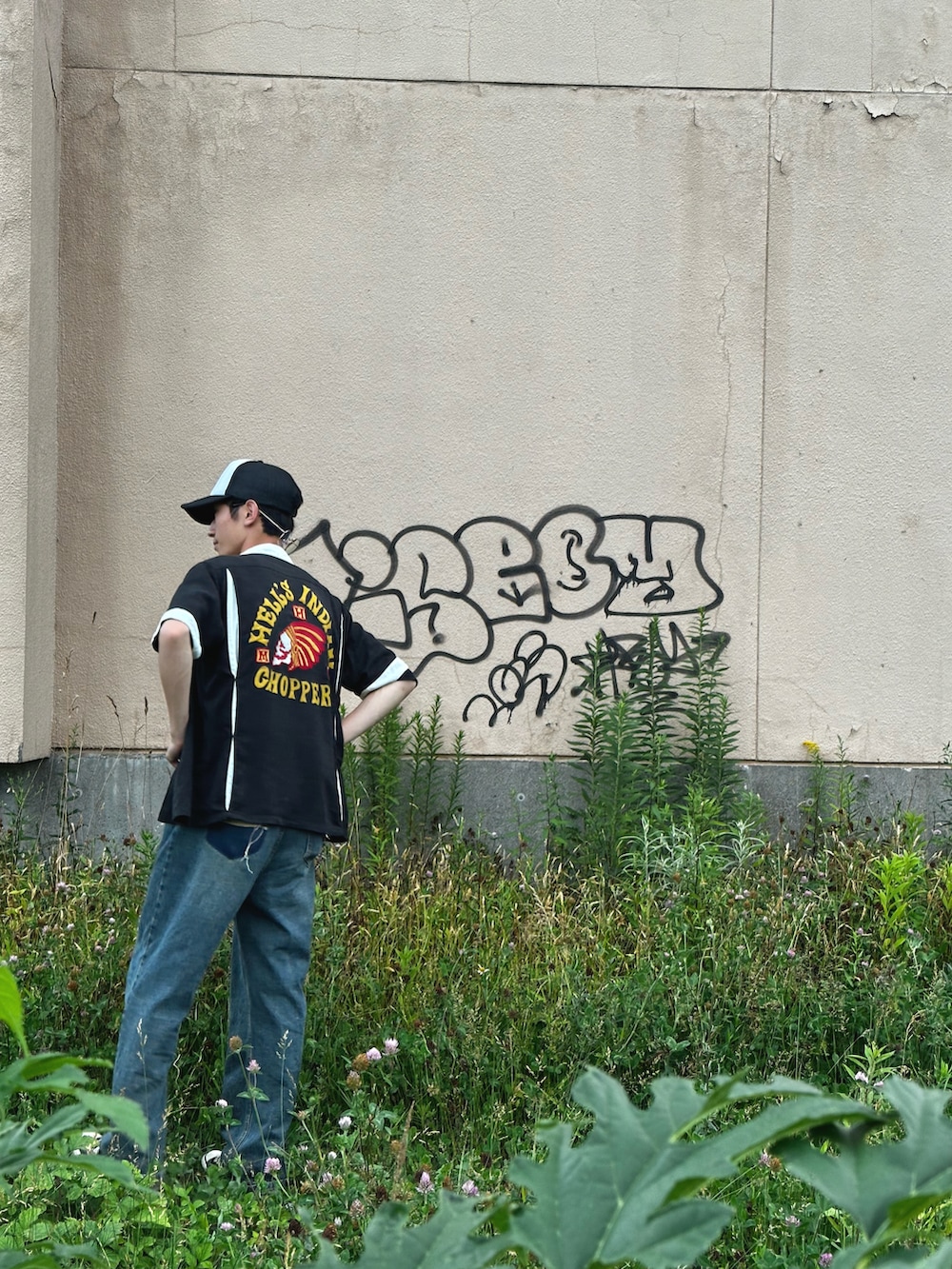 ブルー系のデニムパンツ、ブラック系のスニーカー、ブラック系のTシャツ/カットソーを着用したメンズの春コーディネートの3枚目の写真