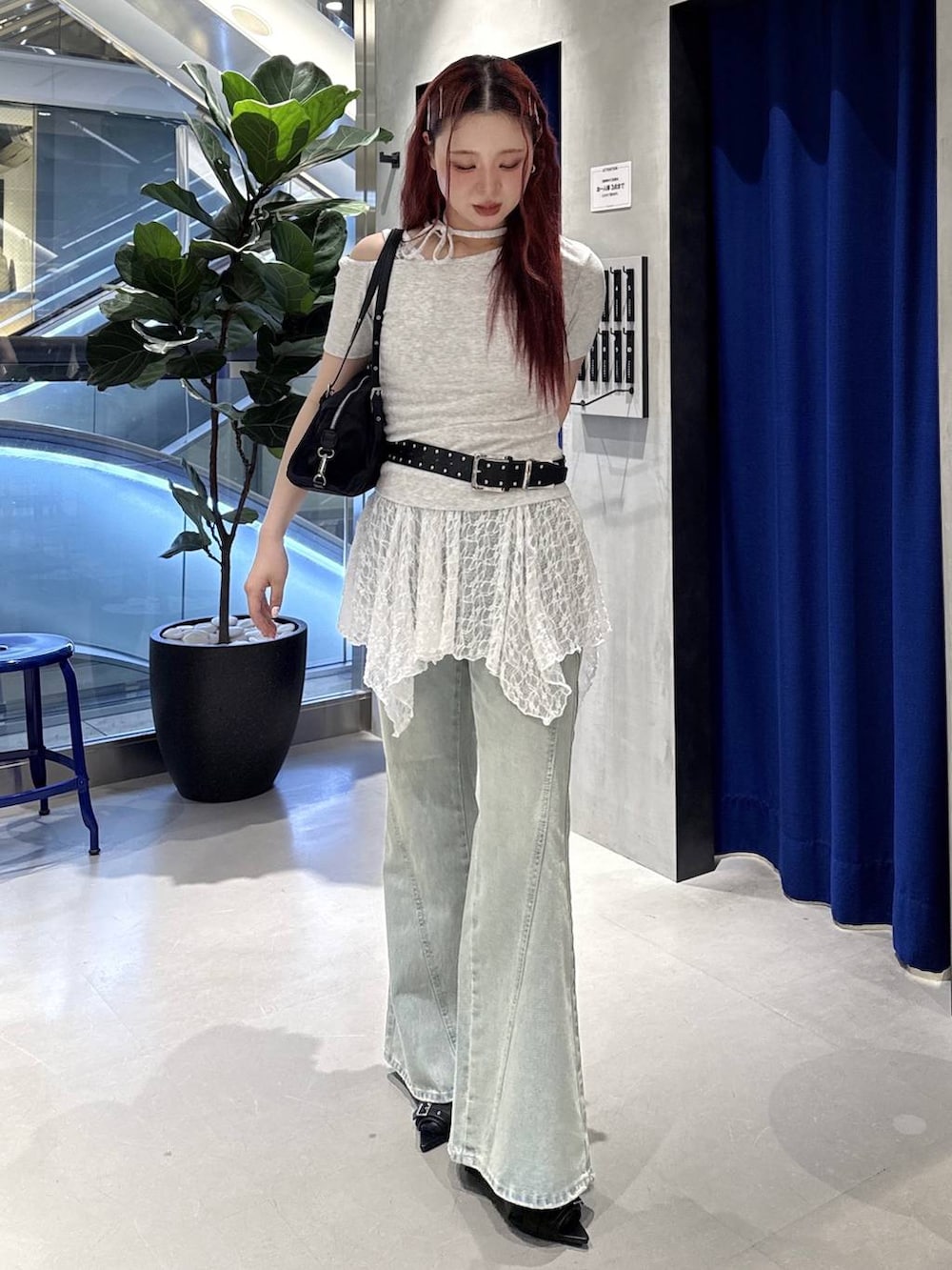 ブルー系のデニムパンツ、ブラック系のサンダル、ブラック系のトートバッグを着用したレディースの夏コーディネートの2枚目の写真