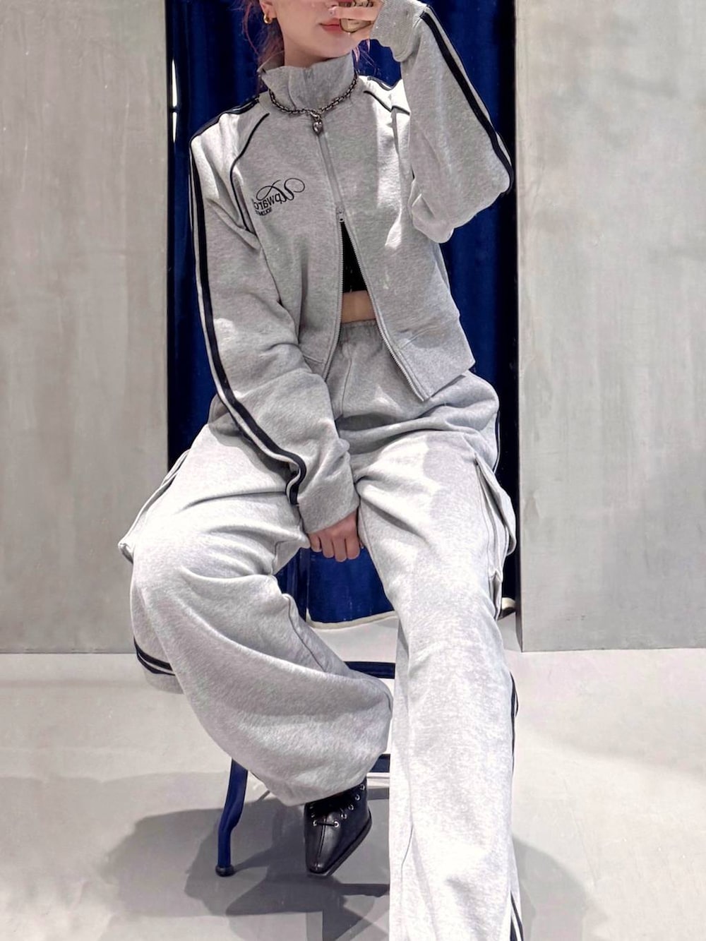 ブラック系のハンドバッグ、ブラック系のサンダル、グレー系のスウェットパンツを着用したレディースの春コーディネートの2枚目の写真