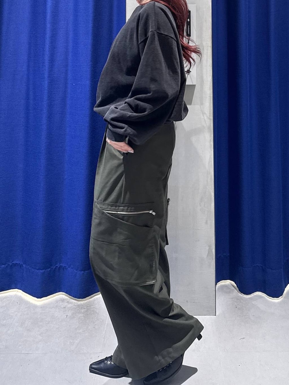 ブラック系のボストンバッグ、グリーン系のスラックス、ブラック系のサンダルを着用したレディースの冬コーディネートの4枚目の写真