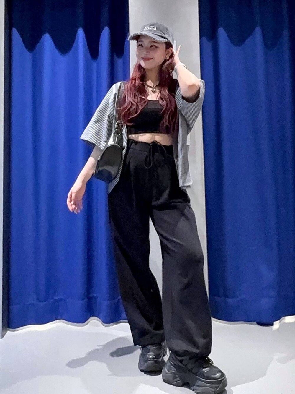 ブラック系のスニーカー、ブラック系のショルダーバッグ、ブラック系のキャミソールを着用したレディースの春コーディネートの3枚目の写真