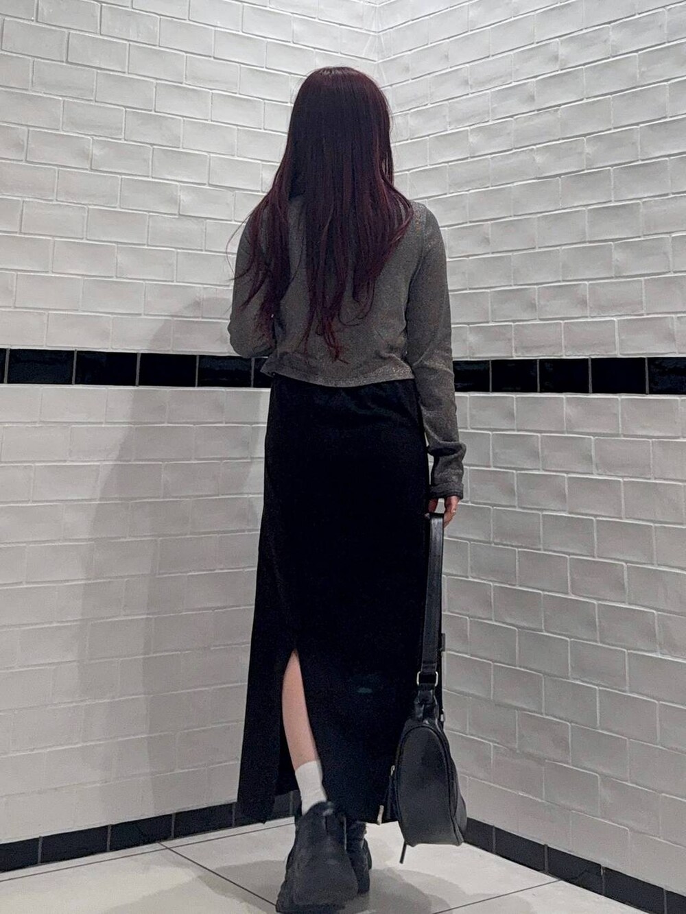 ブラック系のスニーカー、ブラック系のショルダーバッグ、ブルー系のカーディガン/ボレロを着用したレディースの春コーディネートの3枚目の写真