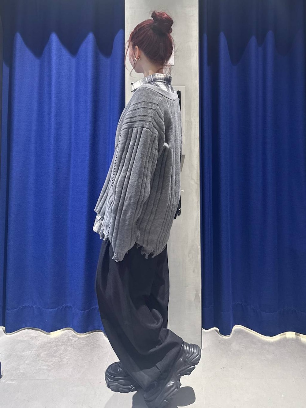 ブラック系のスニーカー、ブラック系のハンドバッグ、ブラック系のスラックスを着用したレディースの秋コーディネートの2枚目の写真