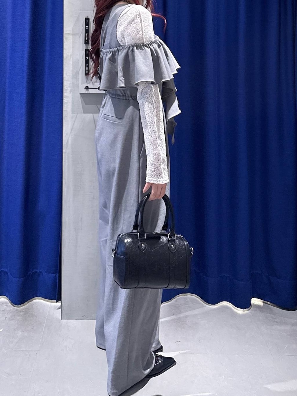 ブラック系のボストンバッグ、ブラック系のサンダル、グレー系のサロペット/オーバーオールを着用したレディースの春コーディネートの2枚目の写真