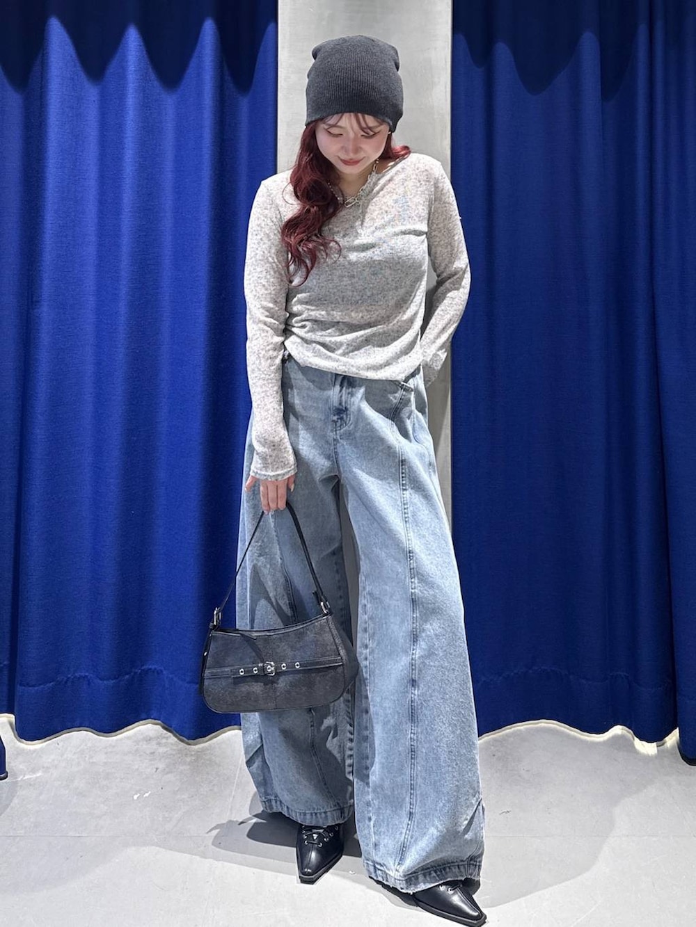 ブラック系のハンドバッグ、ブラック系のサンダル、ブルー系のデニムパンツを着用したレディースの春コーディネートの2枚目の写真