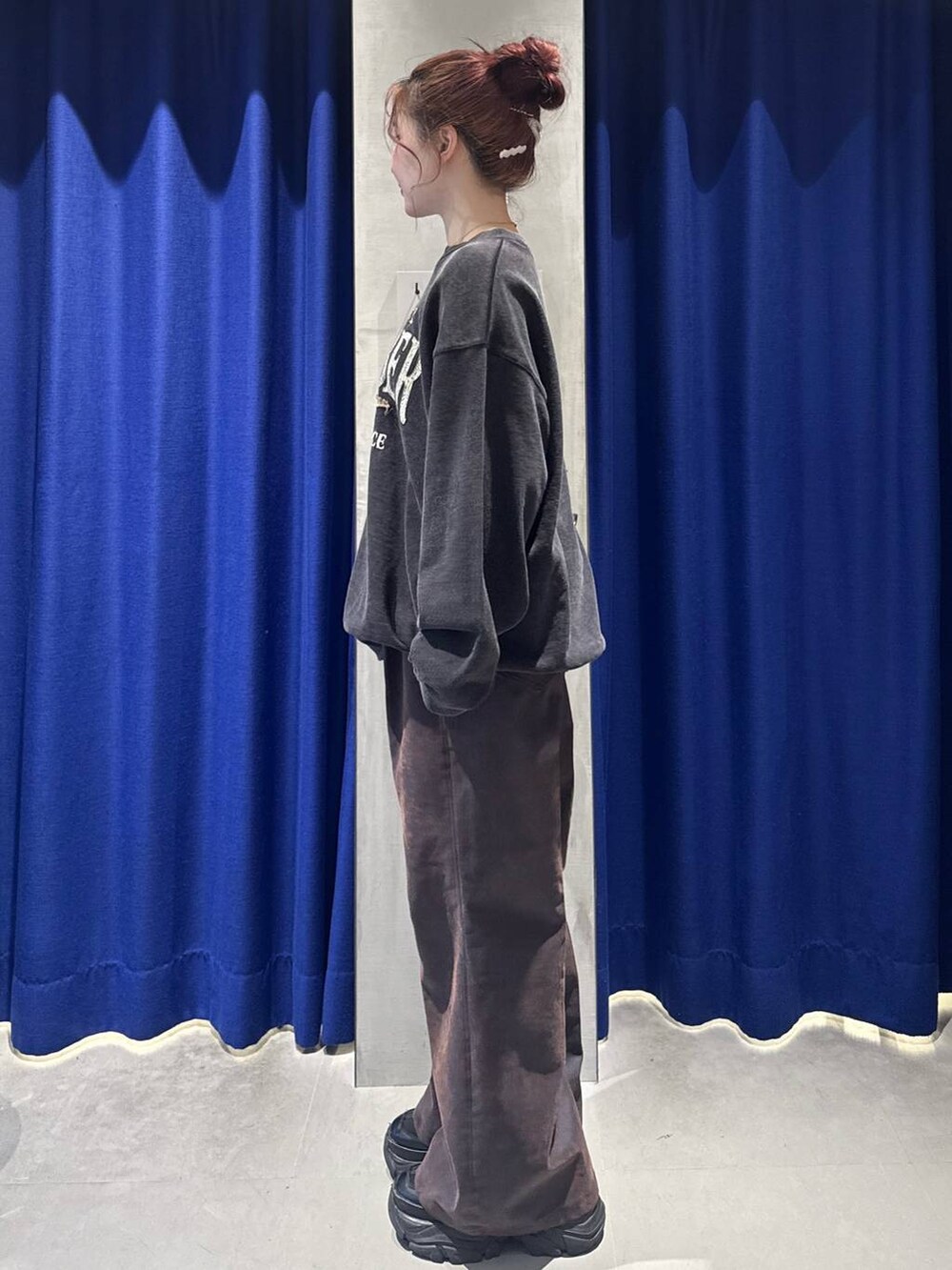 ブラック系のスニーカー、グレー系のスウェット、ブラック系のショルダーバッグを着用したレディースの冬コーディネートの3枚目の写真