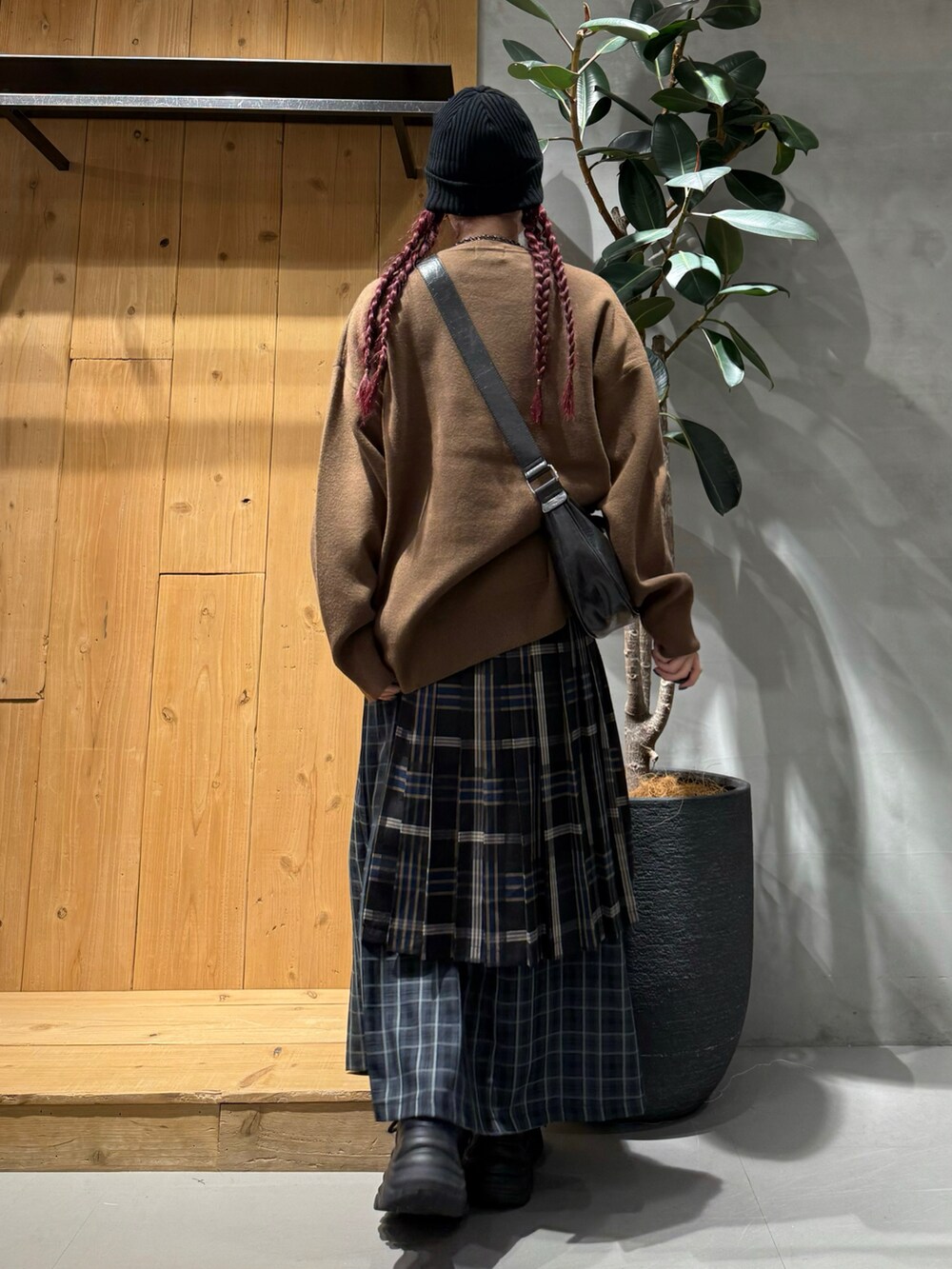 ブラック系のショルダーバッグ、ブラウン系のニット/セーター、ブルー系のスカートを着用したレディースの秋コーディネートの4枚目の写真