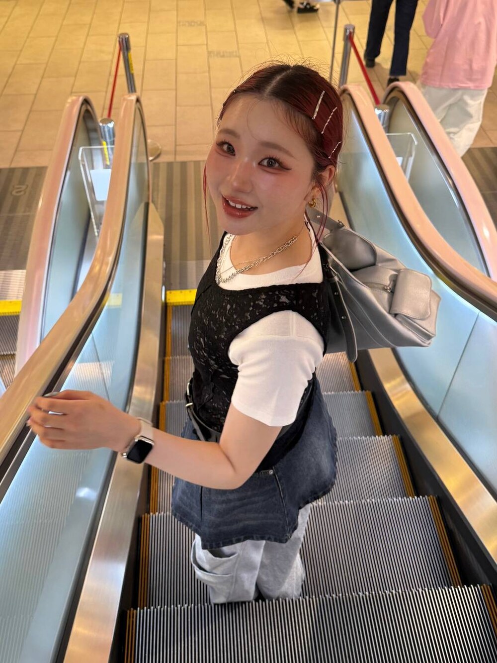 ブラック系のスニーカー、シルバー系のハンドバッグ、ホワイト系のTシャツ/カットソーを着用したレディースの夏コーディネートの2枚目の写真