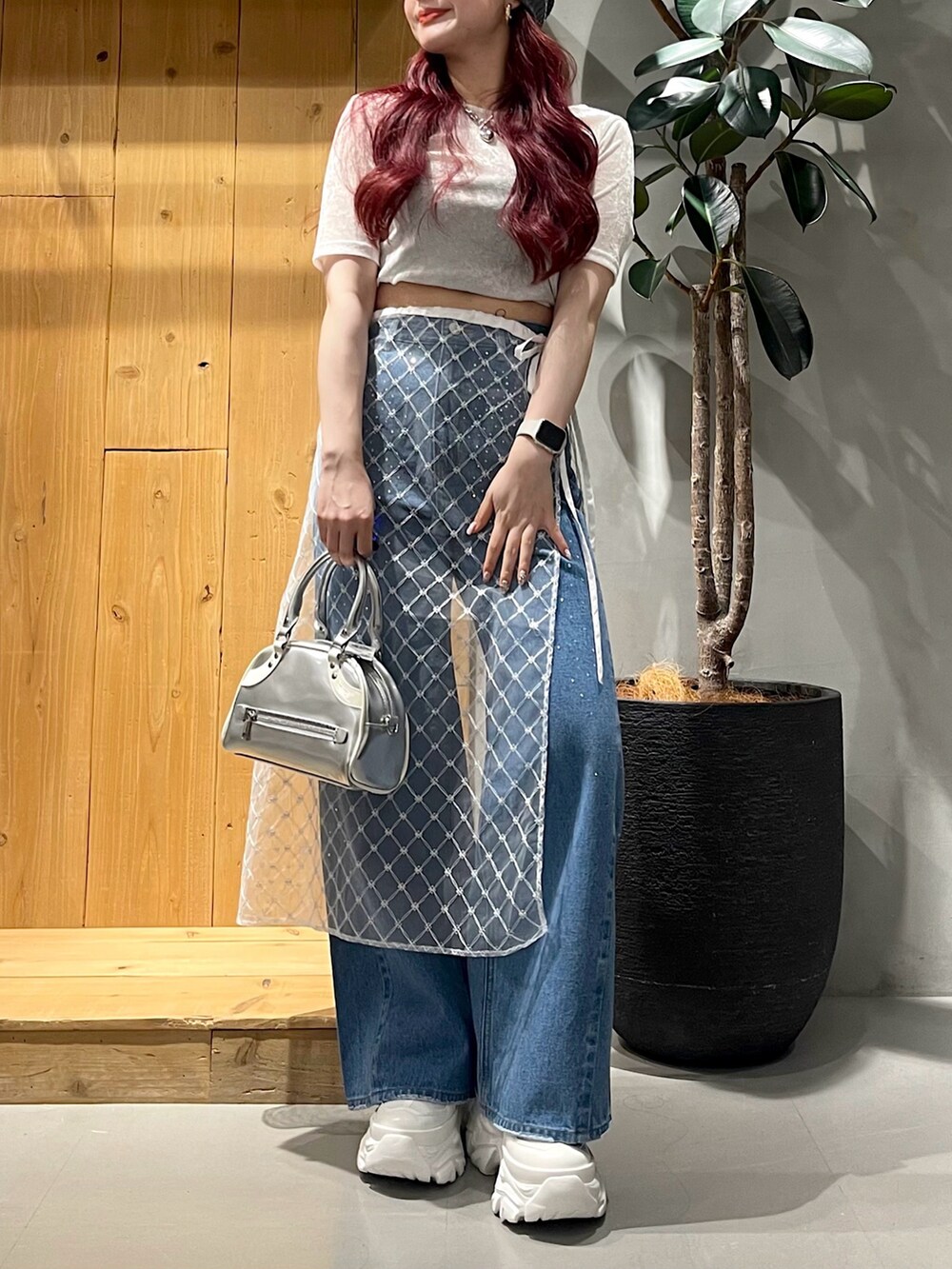 ブルー系のデニムパンツ、シルバー系のショルダーバッグ、ホワイト系のスニーカーを着用したレディースの夏コーディネートの3枚目の写真