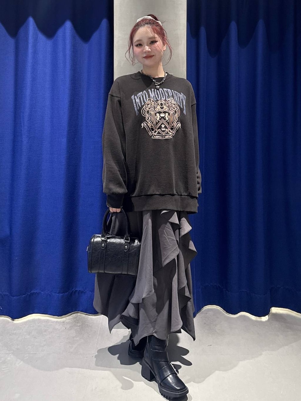 ブラック系のブーツ、グレー系のスカート、グレー系のスウェットを着用したレディースの冬コーディネートの2枚目の写真