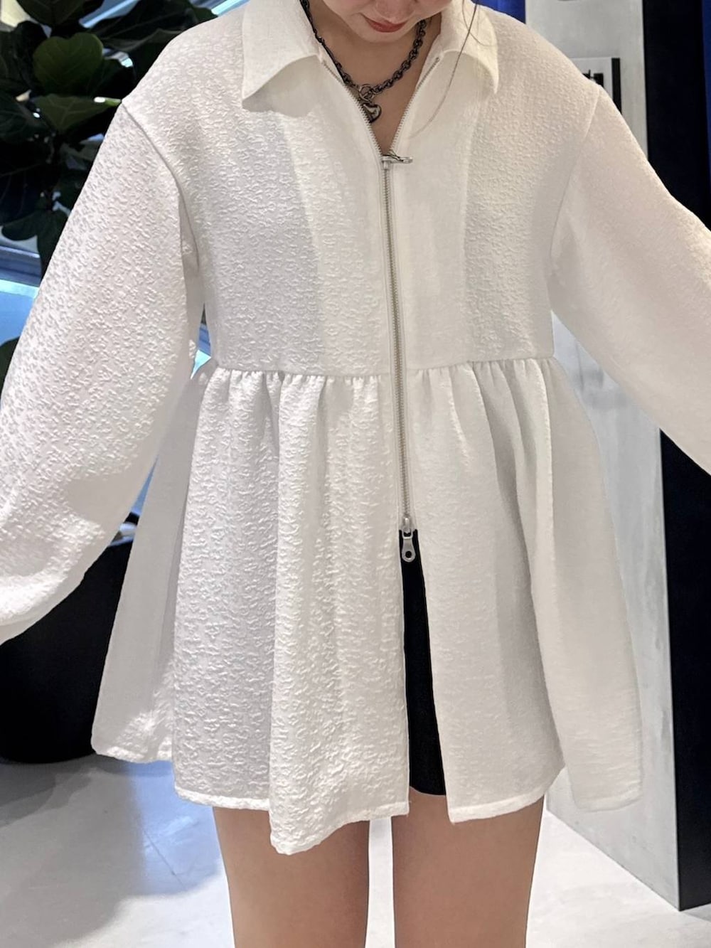 ブラック系のブーツ、ブラック系のハンドバッグ、ブラック系のスラックスを着用したレディースの春コーディネートの3枚目の写真